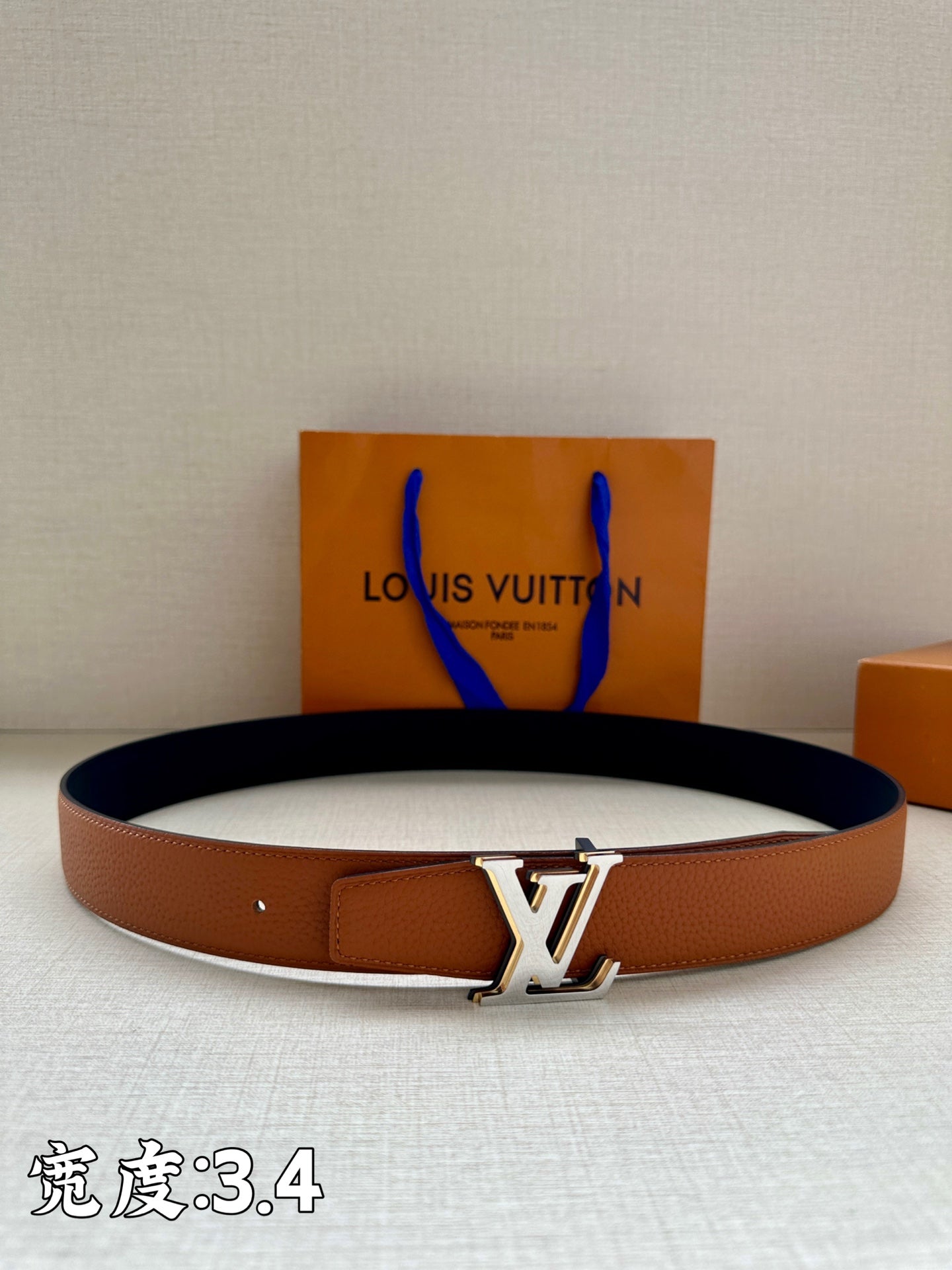 Brown leather belt with black underside and gold-tone LV buckle