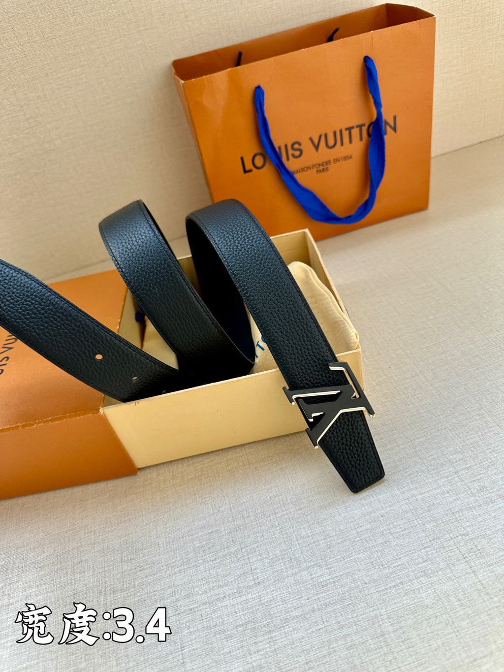 Louis Vuitton leather belt with dark blue straps and gold LV buckle, shown opened
