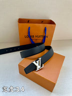 Louis Vuitton belt with dark blue leather and gold LV buckle, resting on shoe boxes