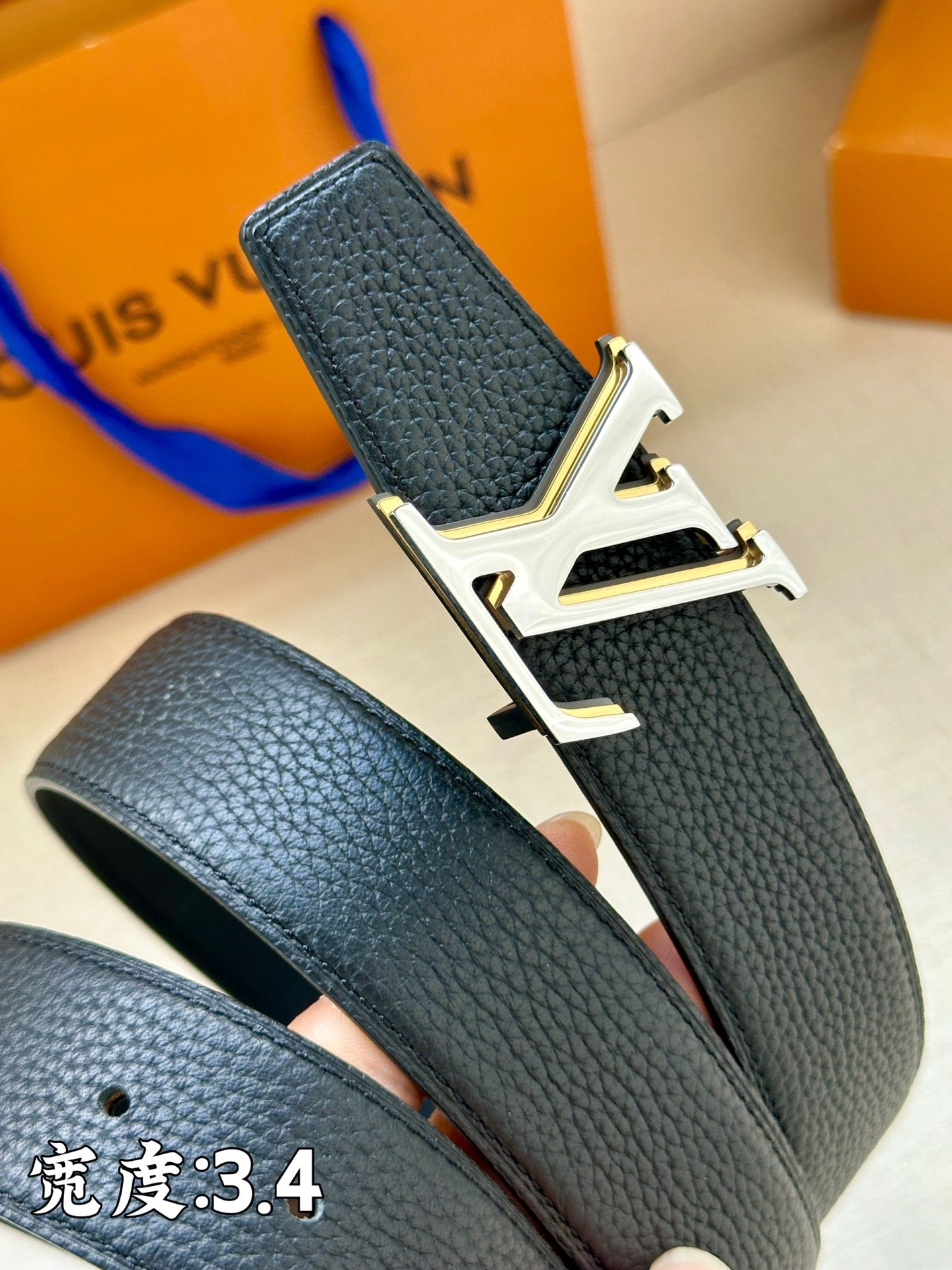 Louis Vuitton belt close-up: textured dark blue leather with gold LV buckle