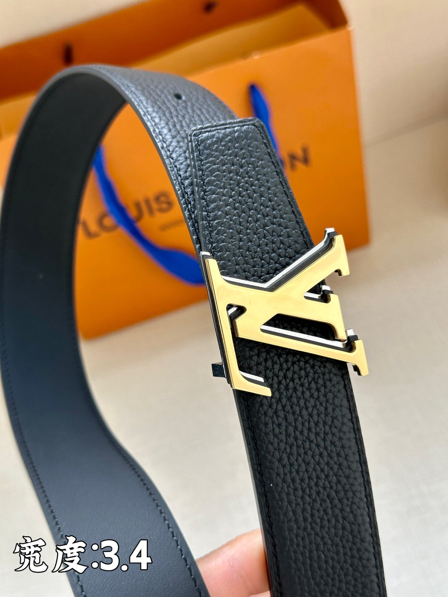 Louis Vuitton belt with textured dark blue leather and gold LV buckle clasp