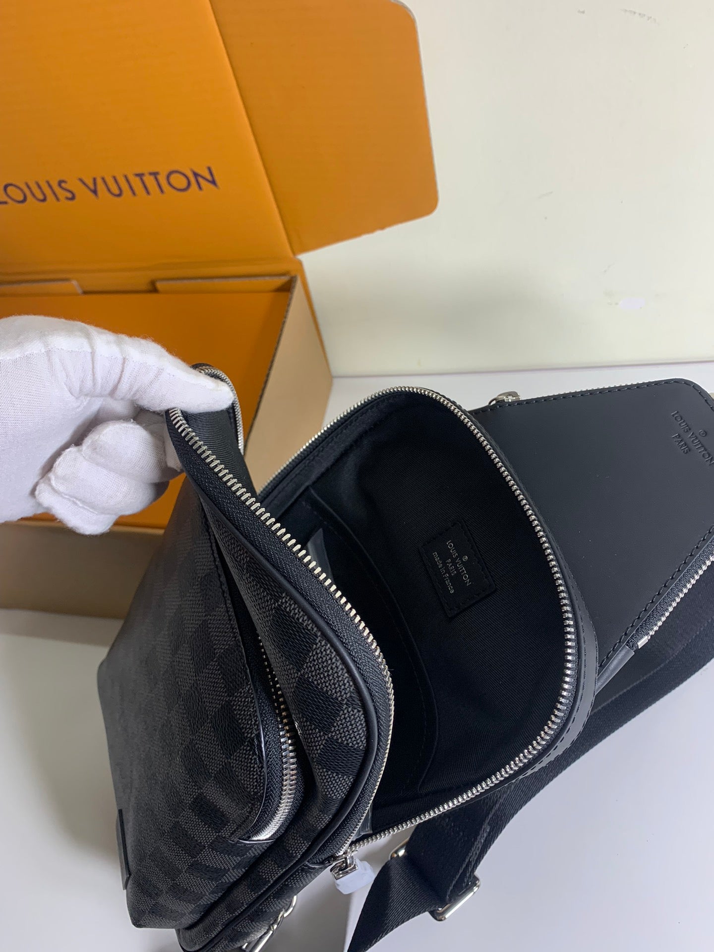 Louis Vuitton bag side view with dual zippers, dark leather trim and Damier panels