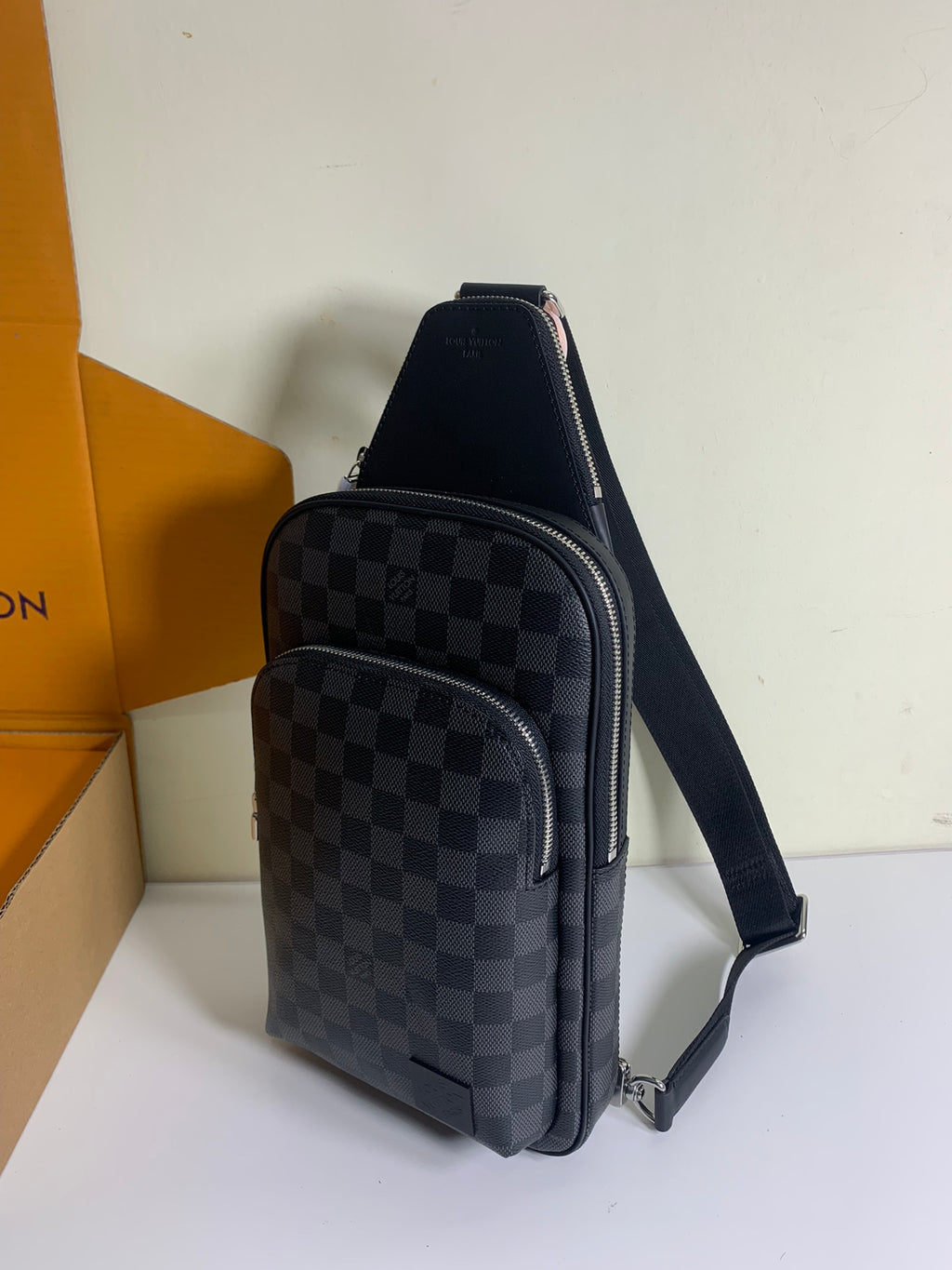 Louis Vuitton crossbody bag with dark Damier check pattern, front zip pocket