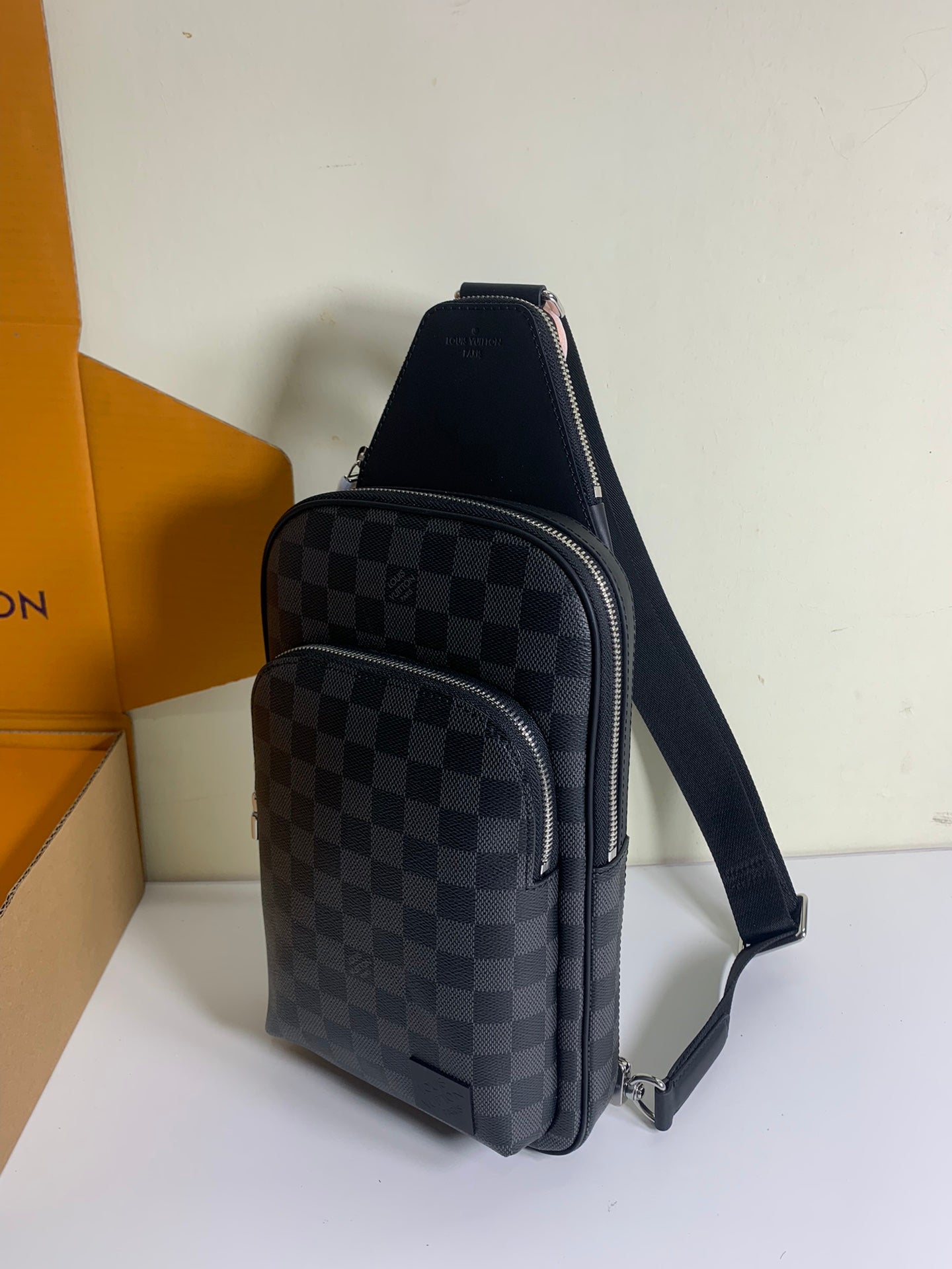 Louis Vuitton crossbody bag with dark Damier check pattern, front zip pocket