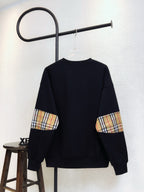 Black Burberry sweatshirt with plaid sleeve cuffs and crew neck