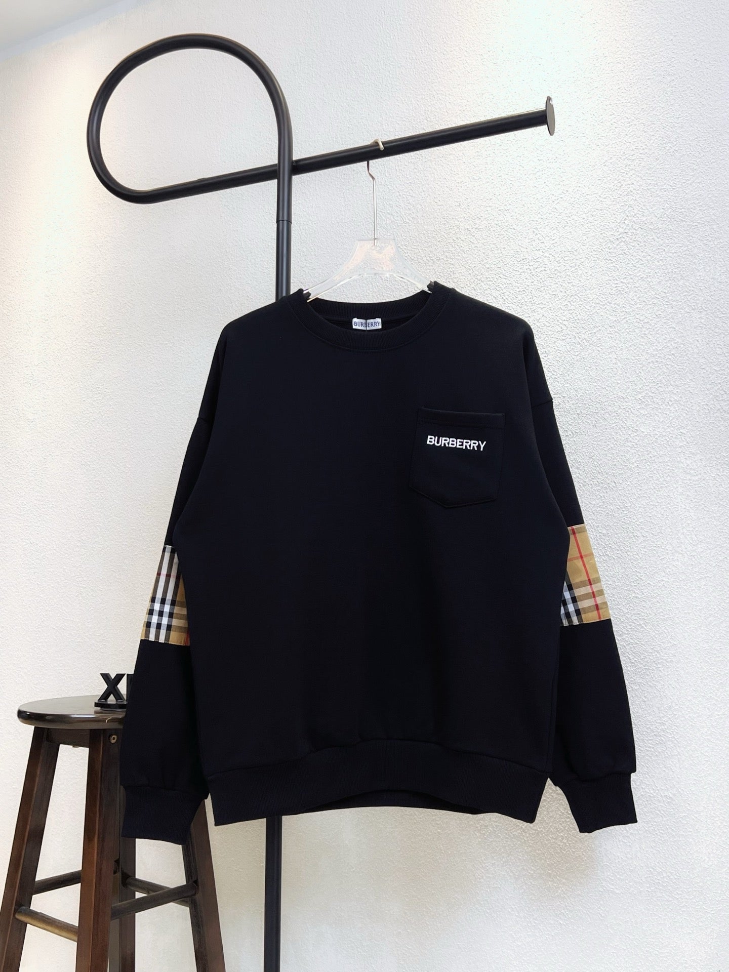 Black Burberry sweatshirt with plaid cuff panels and crew neckline
