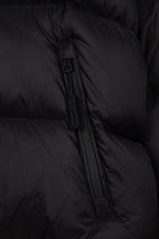Black puffer jacket zipper detail with quilted fabric and stitched channel seams