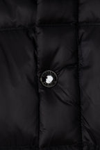 Black puffer jacket front with round button and metal emblem center