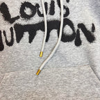 Gray Louis Vuitton hoodie close-up of black logo text and white drawstrings.