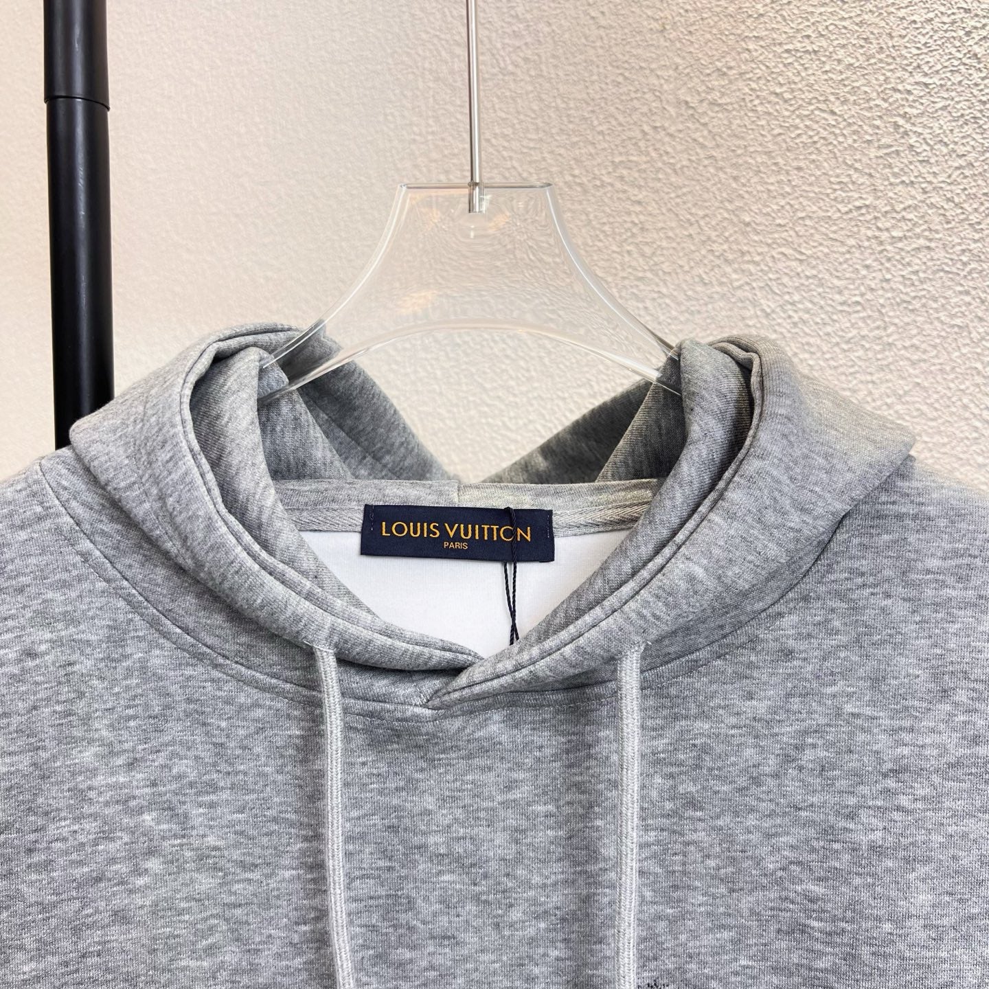 Gray Louis Vuitton hoodie neckline with hood, drawstrings, and logo label.