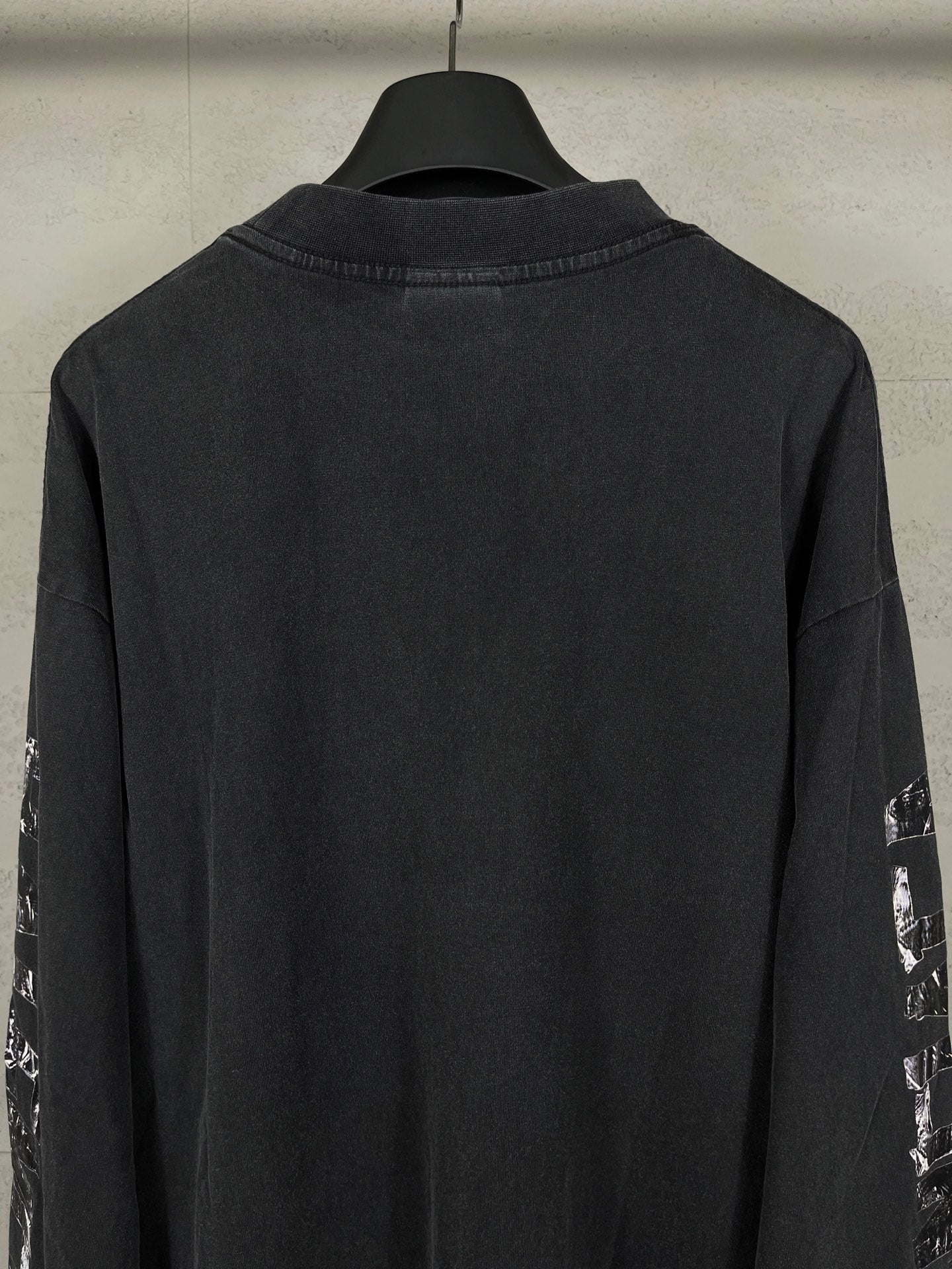 Balenciaga long-sleeve T-shirt back view, dark with printed sleeve logos