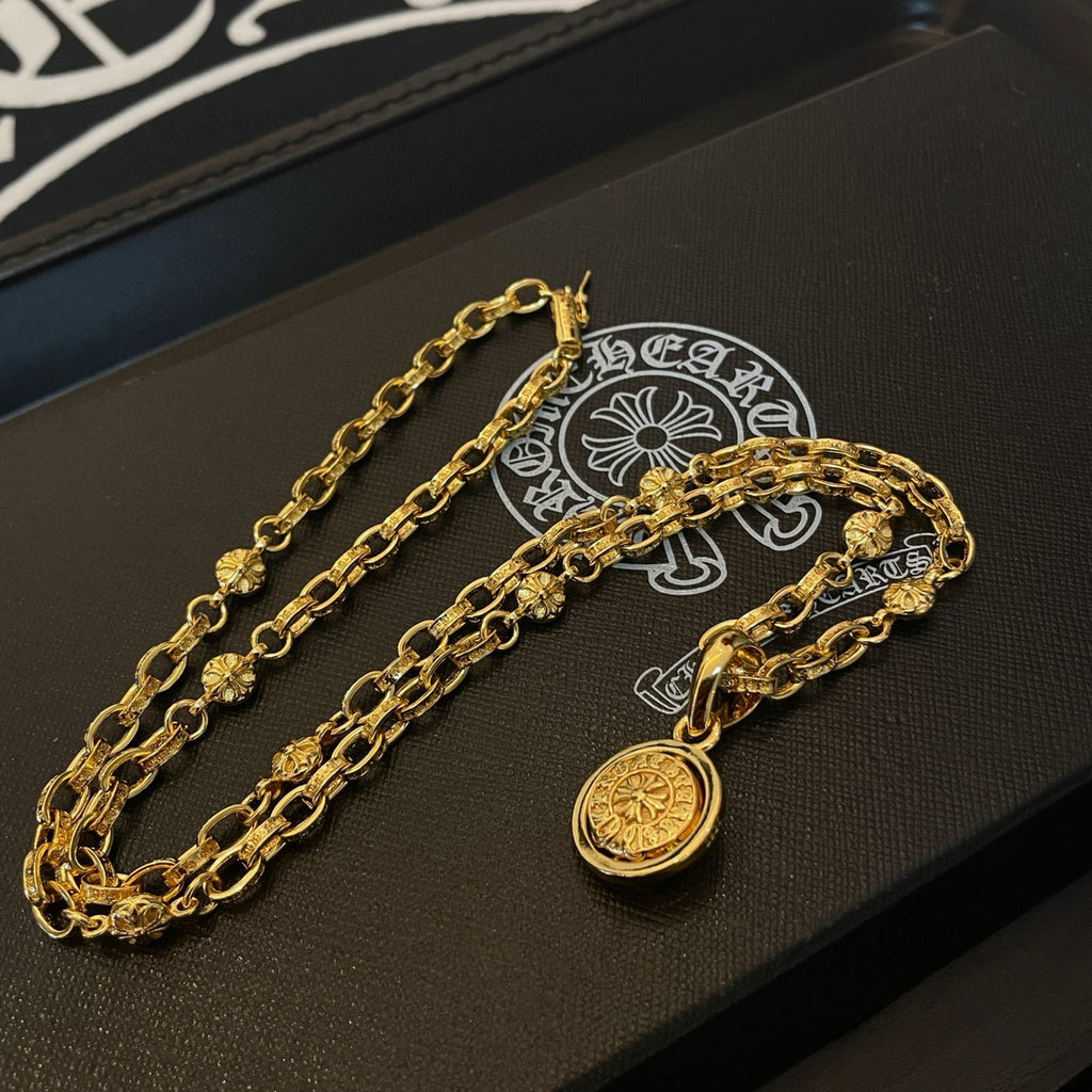 Gold chain necklace set with round pendants on a jewelry box tray