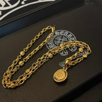 Gold chain necklace set with round pendants on a jewelry box tray
