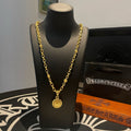 Gold link necklace with round medallion pendant on a display bust