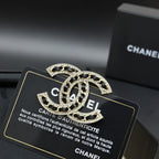 Rhinestone Chanel logo brooch with black enamel, gold-tone crystal trim