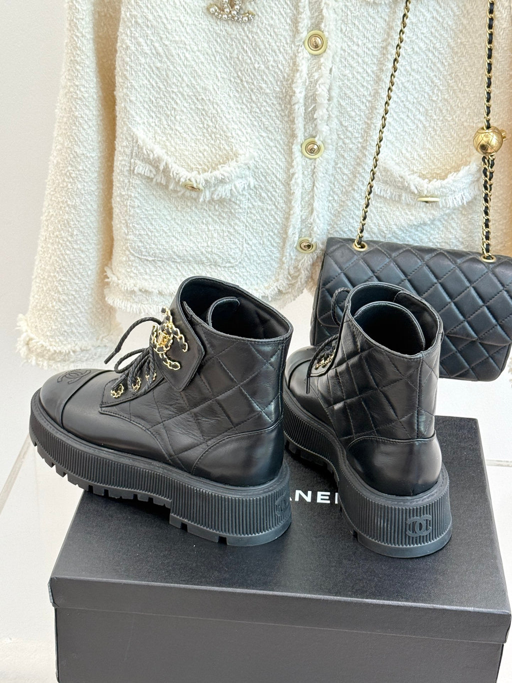 Dark leather lace-up ankle boots with quilted panels, gold hardware, and platform sole