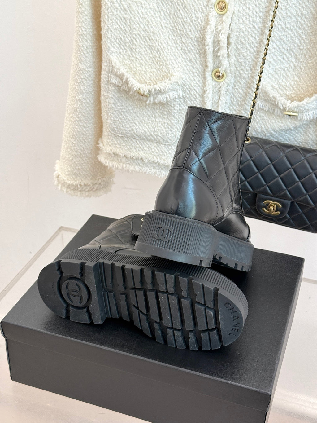 Bottom view of dark platform boots on a box showing chunky lug tread