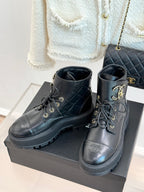 Dark high-top lace-up boots with gold logo medallion eyelets and ribbed platform sole