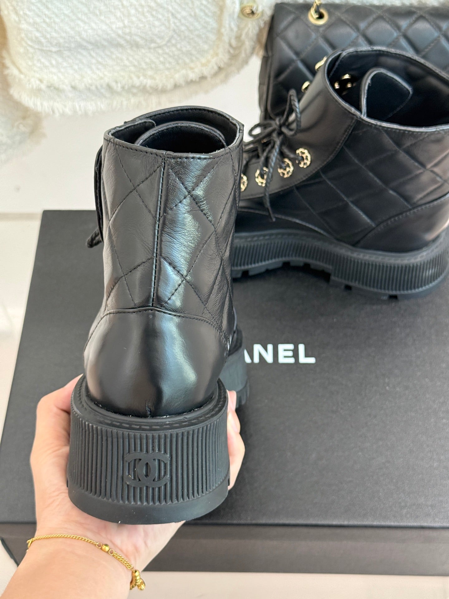 Dark leather lace-up boots showing heel and tread with gold chain lace detail