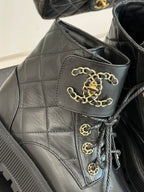 Dark quilted boot upper with gold chain lace detail and logo emblem