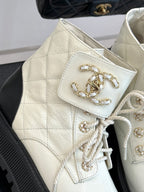 White quilted ankle boot with lace-up front and gold chain logo charm detail