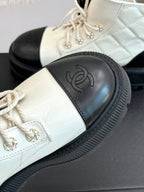 White leather ankle boot with black toe panel and ridged rubber sole