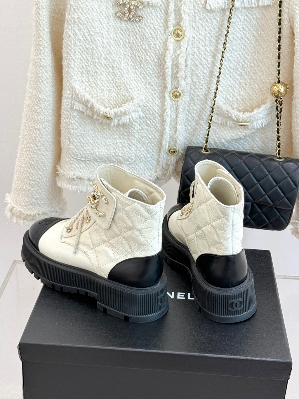 White leather lace-up ankle boots with black toe caps and ridged rubber soles