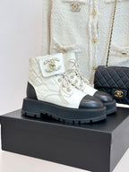 White leather lace-up ankle boots with black toe caps and chunky ridged sole