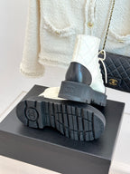 Boot outsole bottom view with ridged tread and logo on thick platform sole