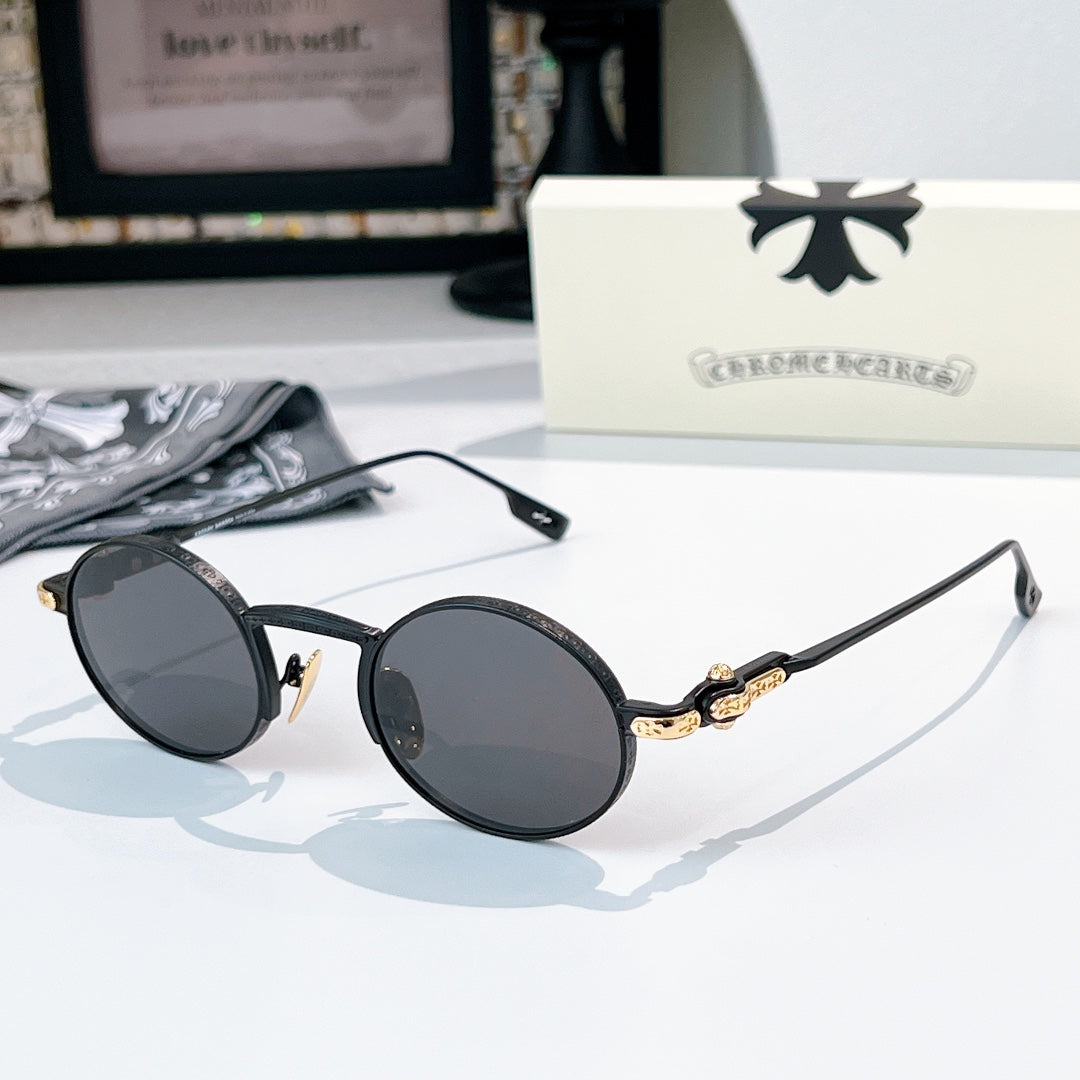 Chrome glasses with black round frames and dark lenses, gold-tone temple hardware detail.