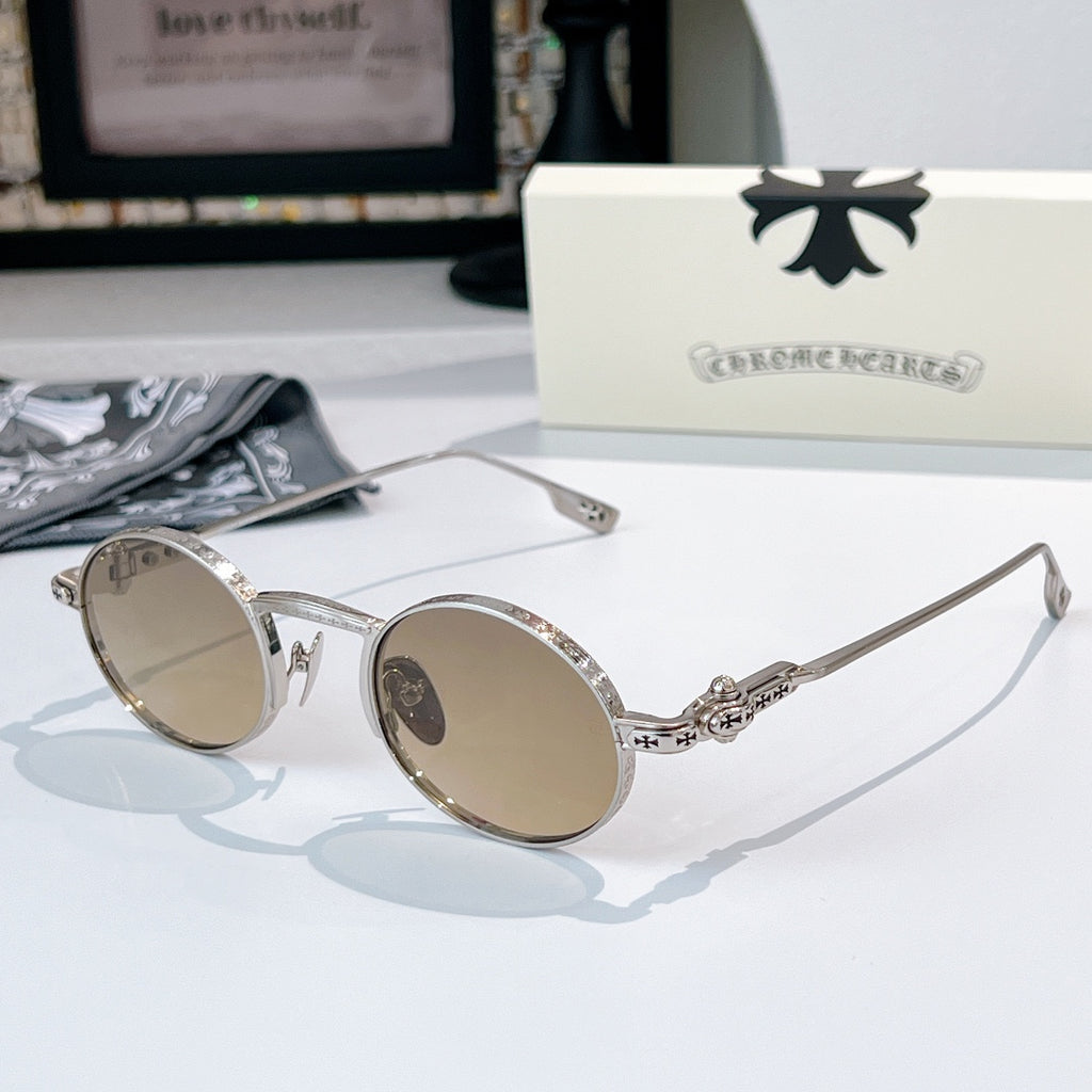 Chrome glasses with silver-tone round frames and amber-tint lenses, ornate metal temple accents.