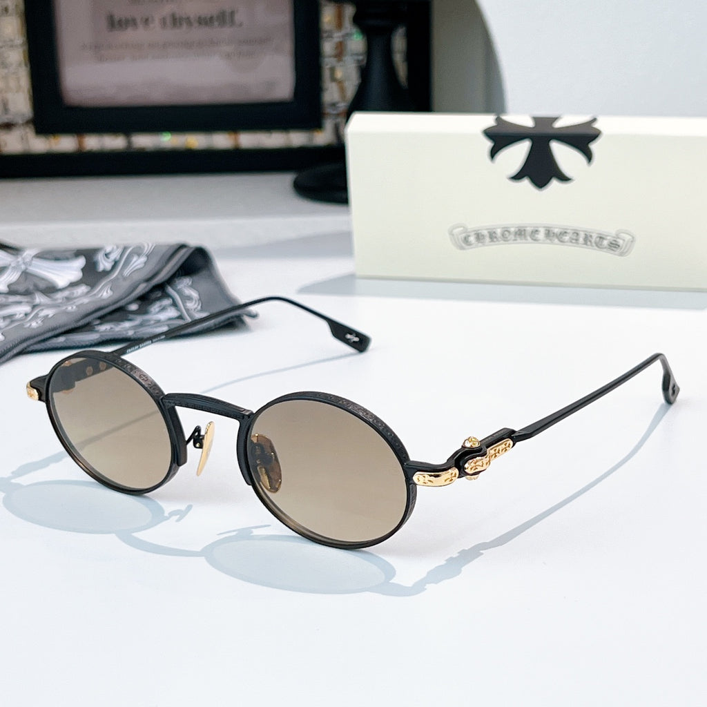 Chrome glasses with black round frames and light beige-tint lenses, gold-tone metal bridge detail.