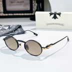 Chrome glasses with black round frames and light beige-tint lenses, gold-tone metal bridge detail.