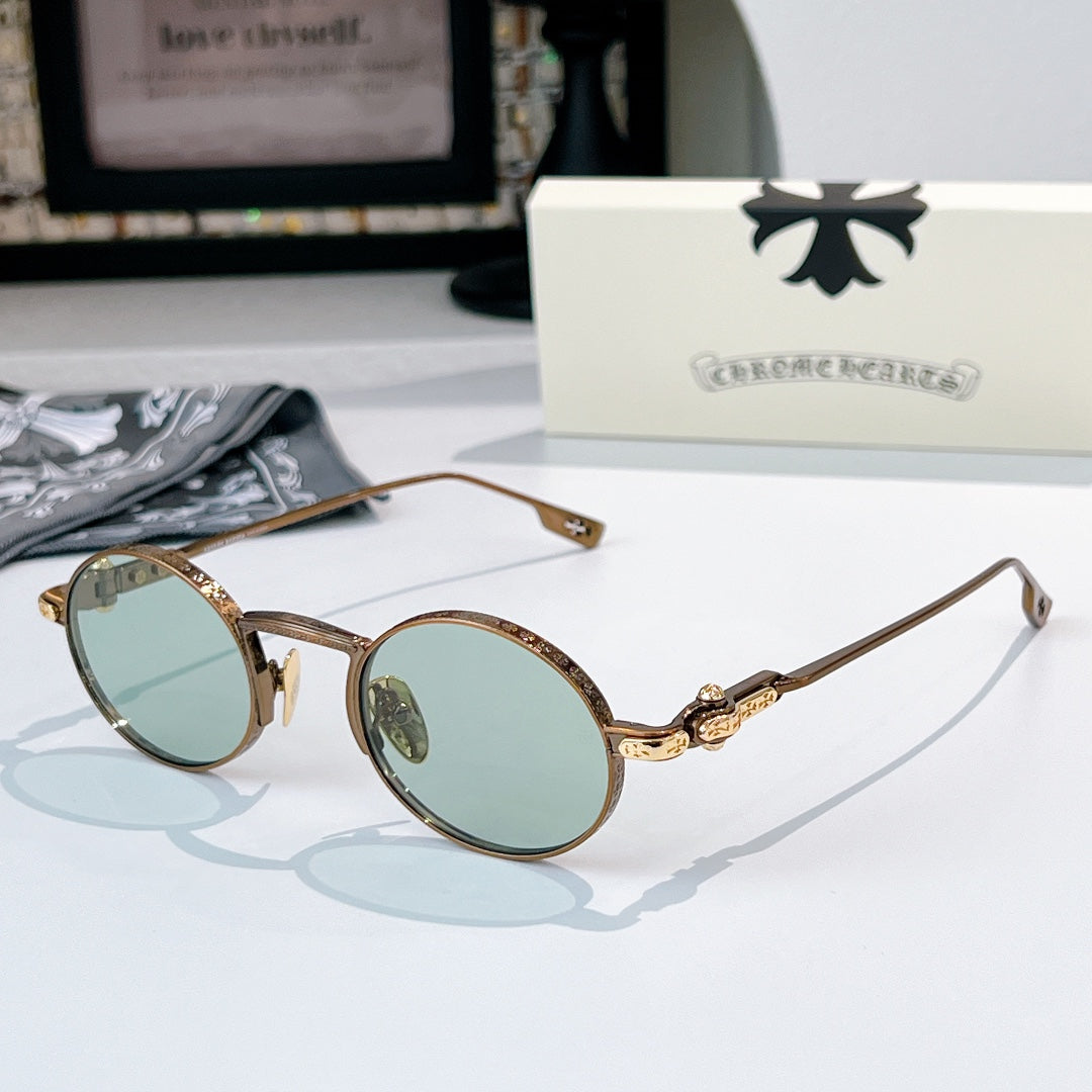 Chrome glasses with brown round frames and light blue-tint lenses, gold-tone metal hinge detail.