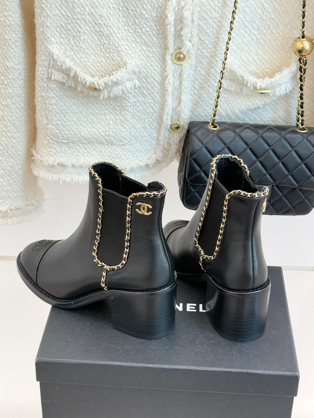 Ladies dark ankle boots with gold chain detail, block heel, and side logo