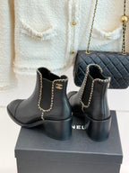 Ladies dark ankle boots with gold chain detail, block heel, and side logo