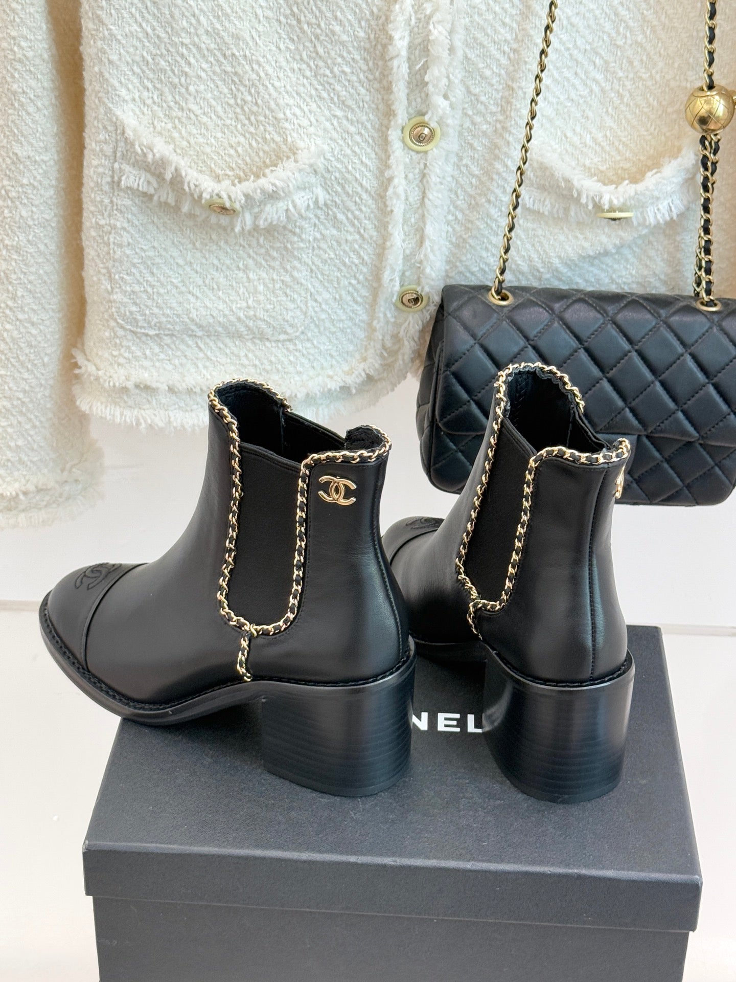 Ladies dark ankle boots with gold chain detail, block heel, and side logo