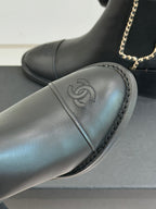 Ladies dark leather ankle boot with gold chain and embossed logo on toe