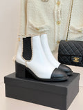White and black leather Chelsea boots with block heel and gold-trimmed collar.