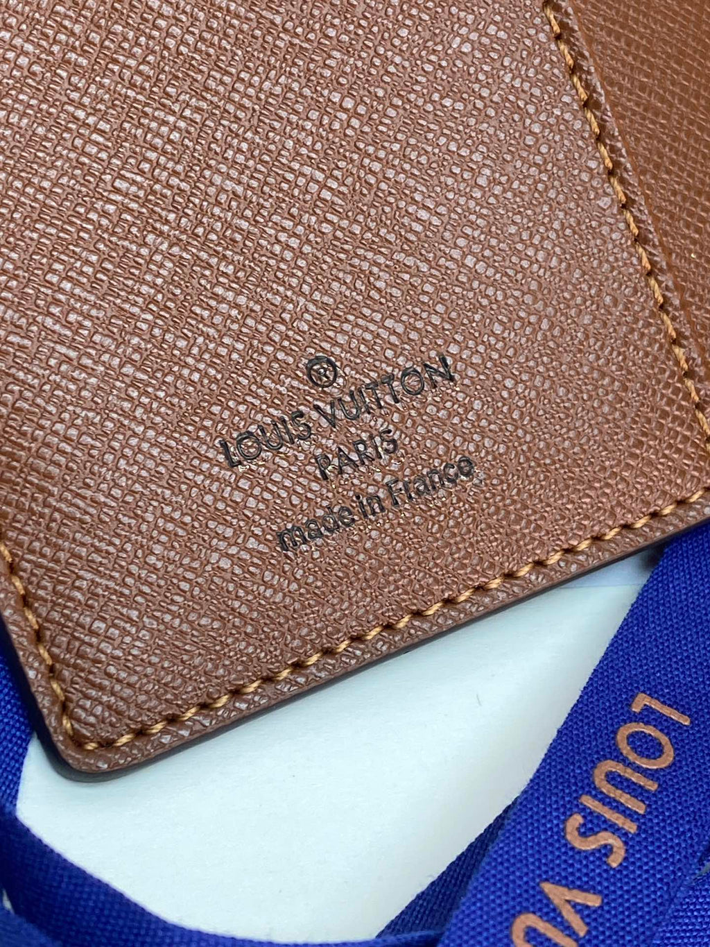 Brown Louis Vuitton small bag close-up of logo stamp and stitched edge