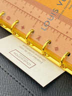 Tan small leather bag with gold ring hardware and card tag attached