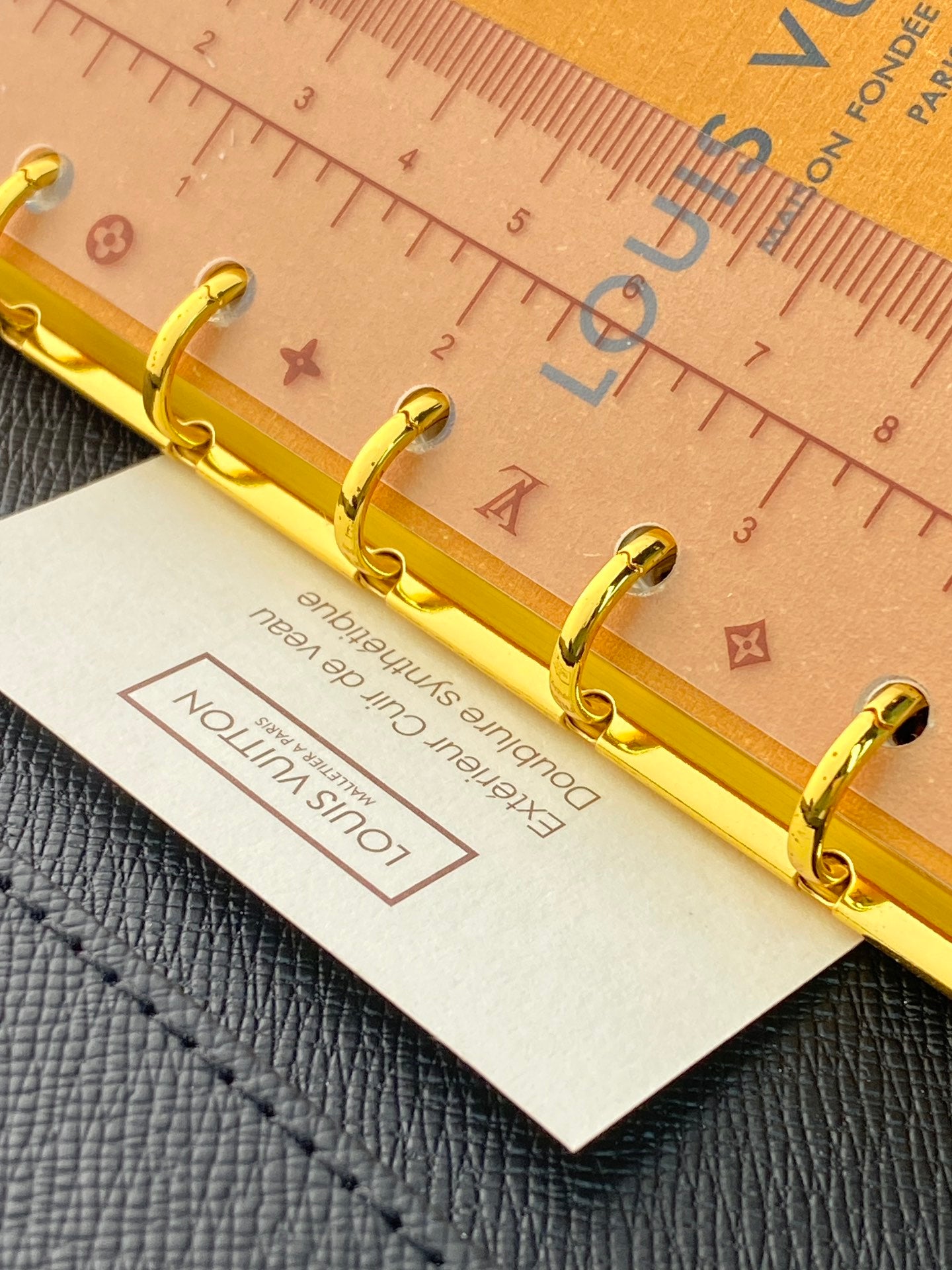 Tan small leather bag with gold ring hardware and card tag attached