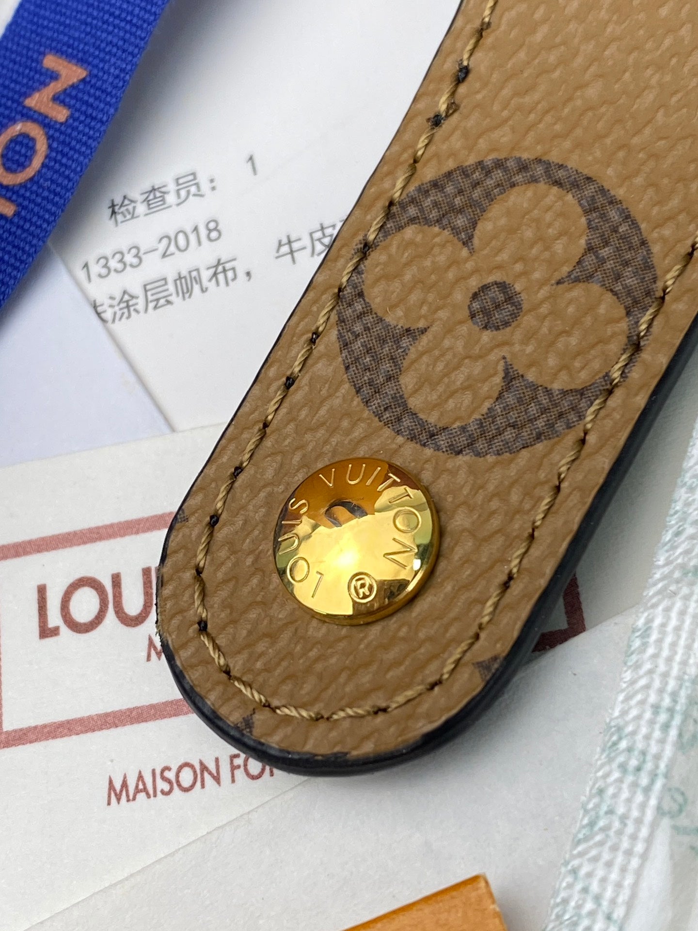 Brown leather small bag tab with clover emblem and round gold snap button