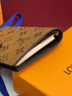Small leather bag with monogram pattern, blue strap, open top showing card slot