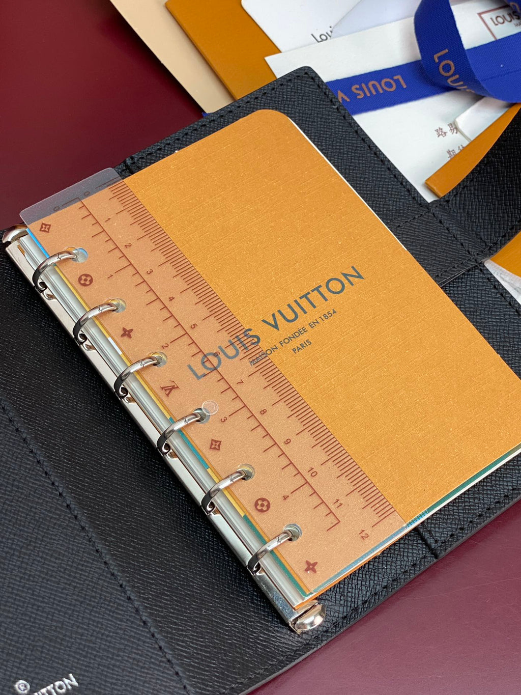 Louis Vuitton small bag, ring-bound planner with ruler insert on tan paper