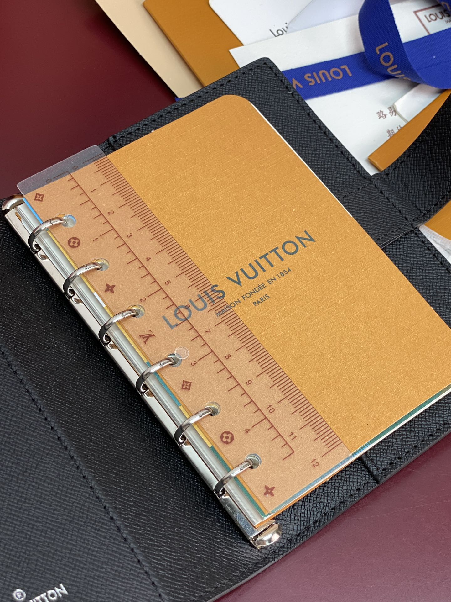 Louis Vuitton small bag, ring-bound planner with ruler insert on tan paper