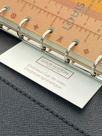Black small bag with three metal rings and Louis Vuitton product card