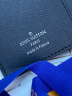 Louis Vuitton small bag close-up, fabric text 'made in France' and blue strap