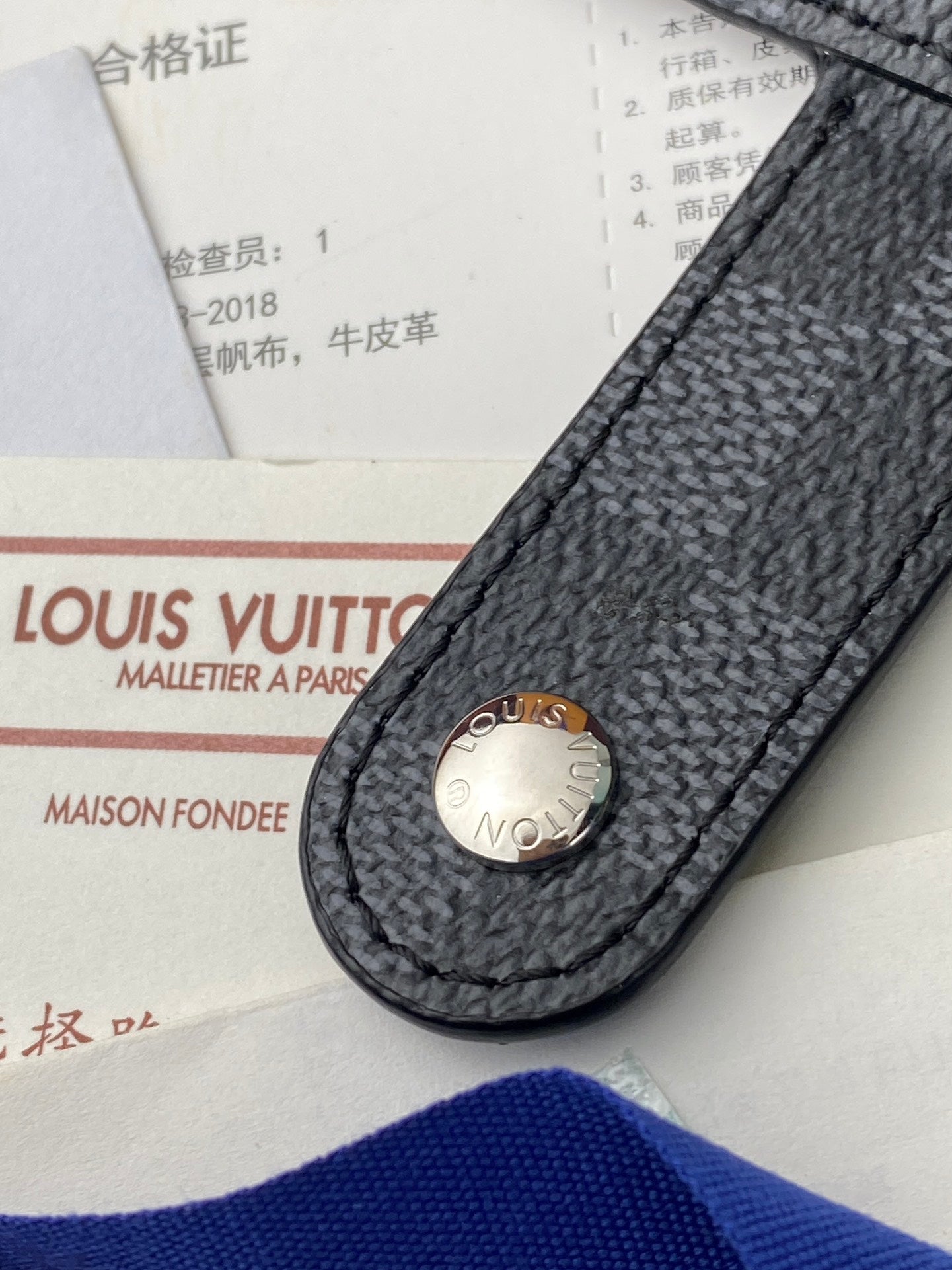 Small bag with dark textured leather flap and oval logo snap button