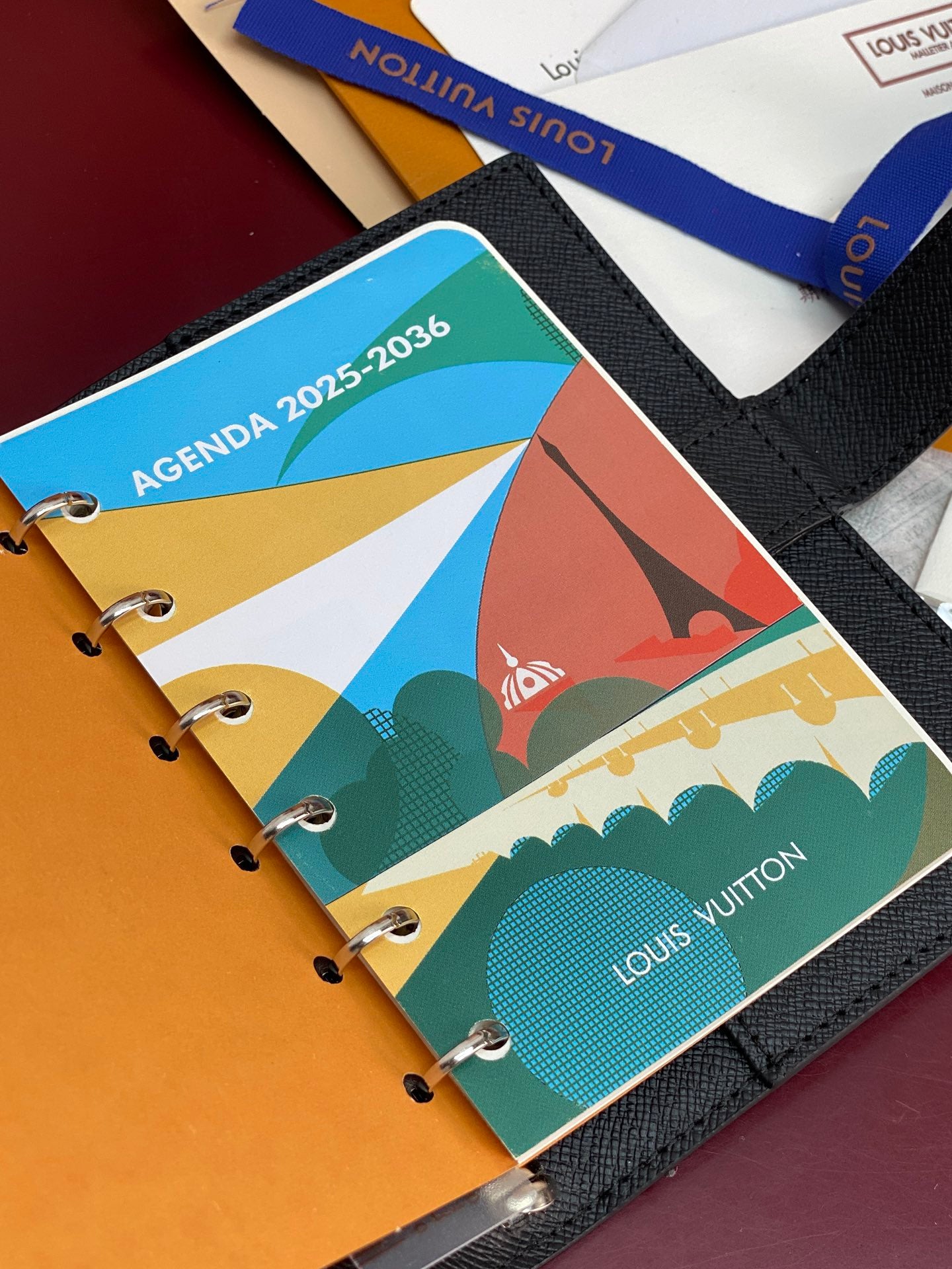 Louis Vuitton small bag open, colorful agenda pages with metal ring binder